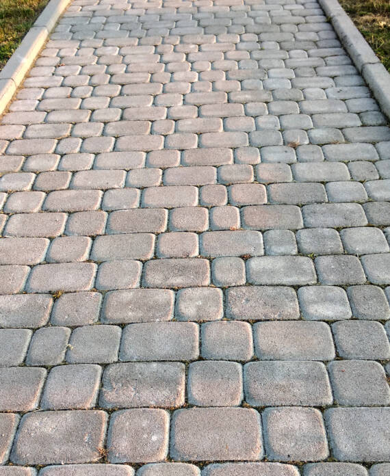 Close-up of slab stone paved path way at park or backyard. Walkway footpath road at house yard garden.